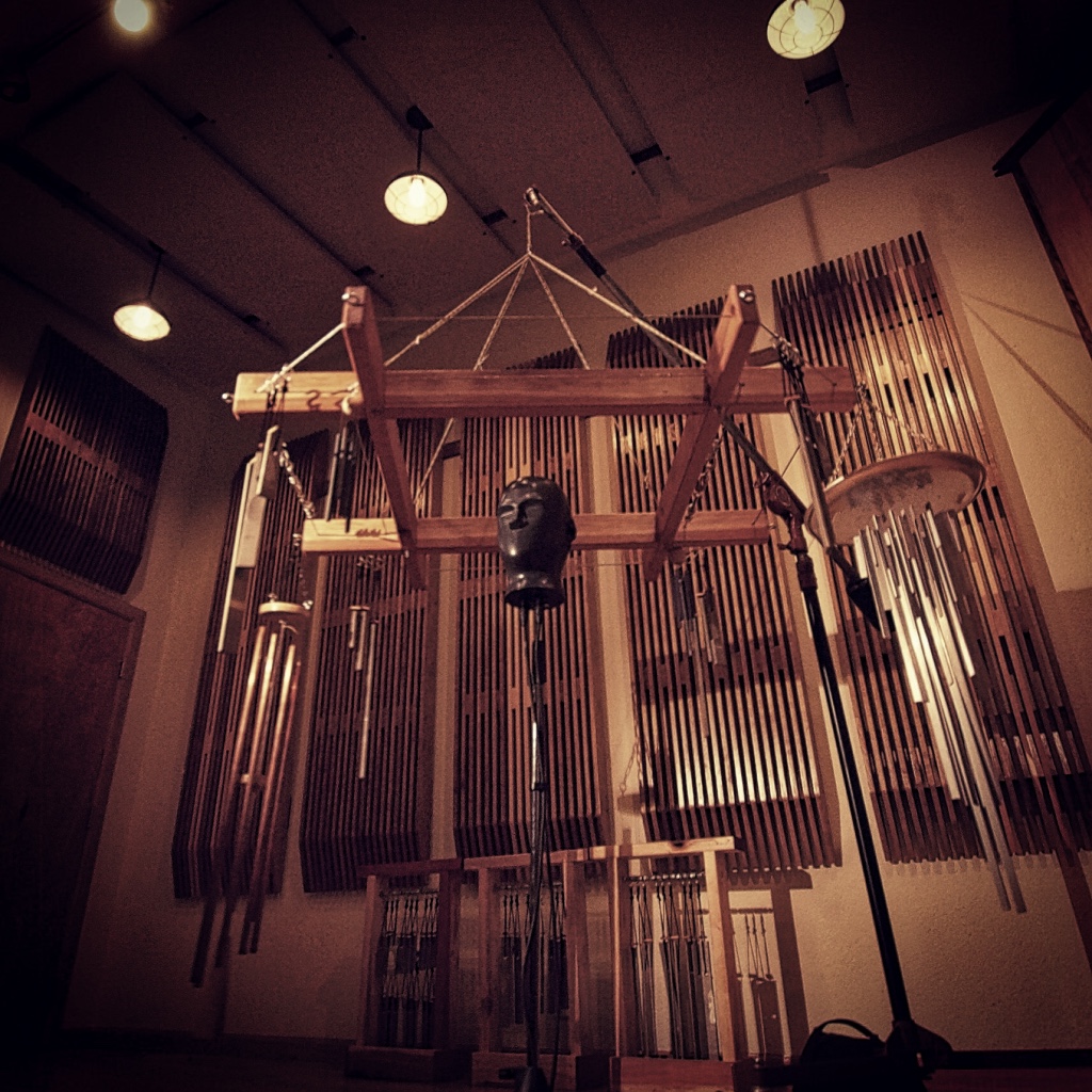 a binaural microphone in a studio surrounded by hand built chimes.