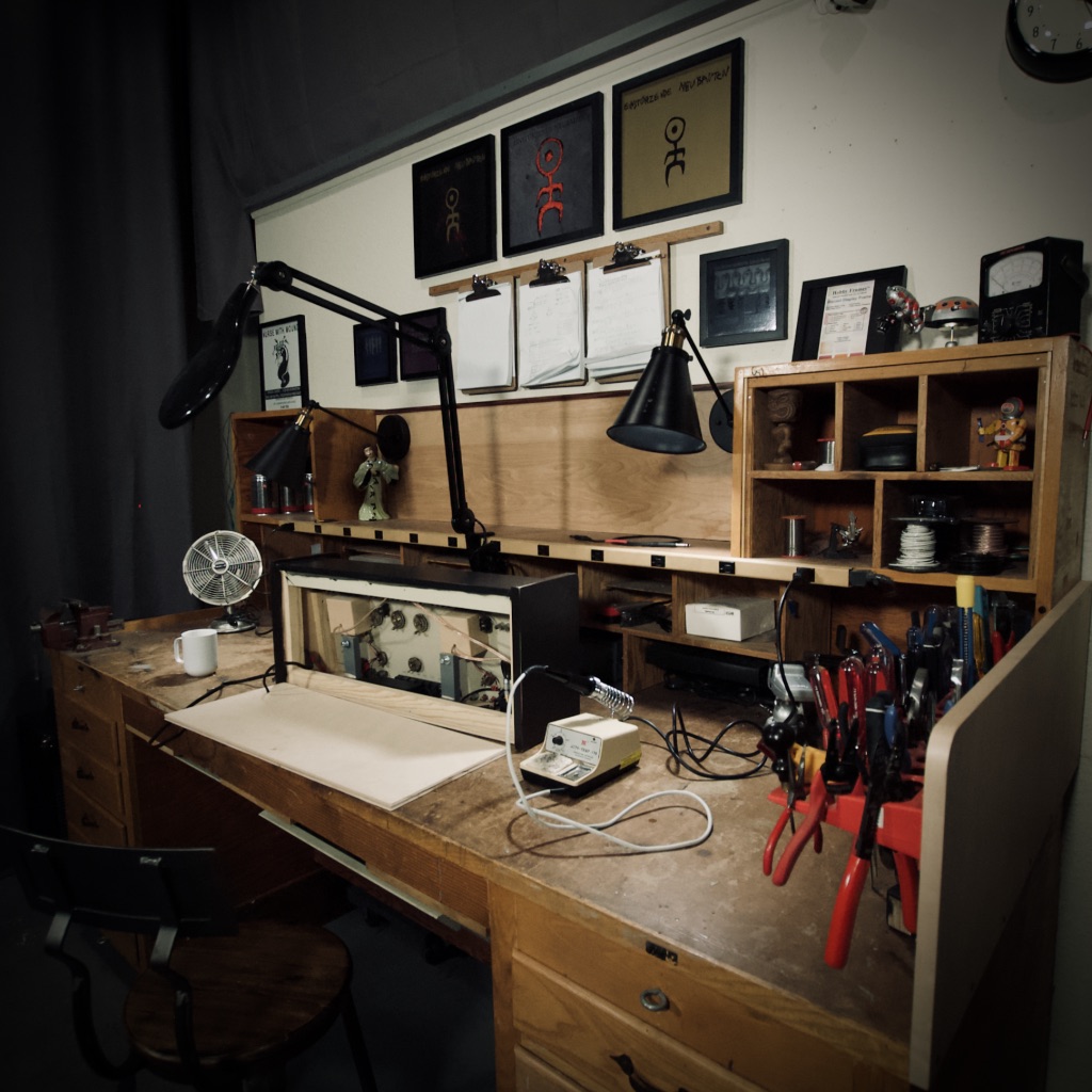 Workbench with tools, test equipment, and storage shelves.