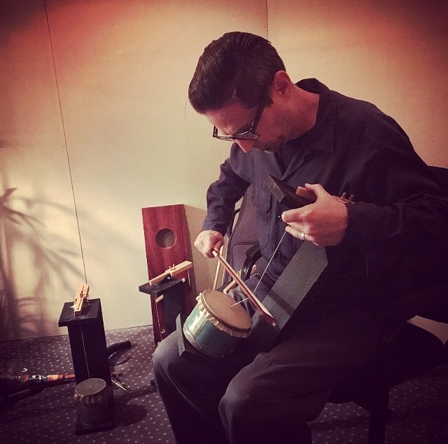 A soundmaker performes a bowed sound effect device