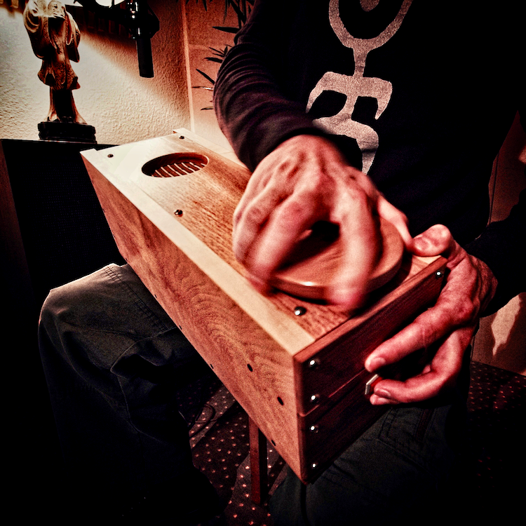 Sound artist manipulates a custom built wooden sound effect box.