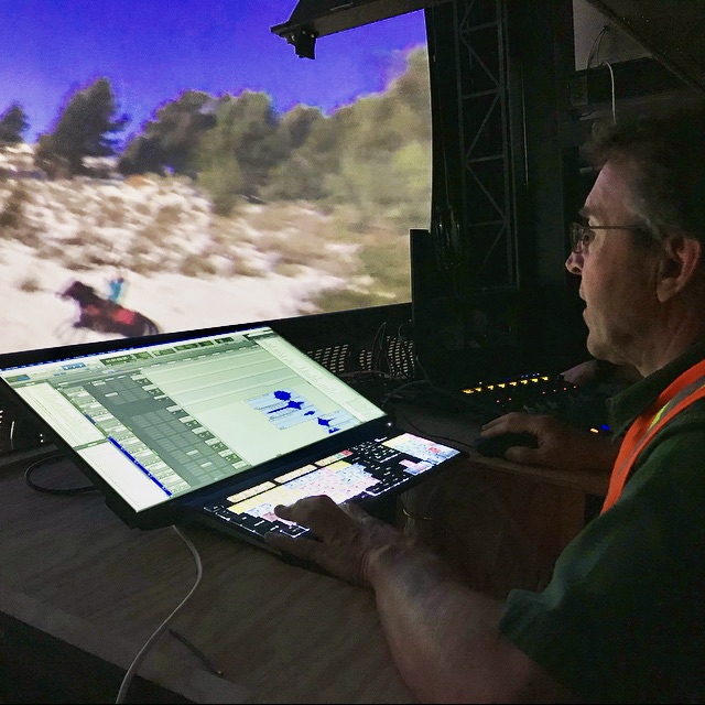 Audio mixer manipulates workstation during a large format theater mix.